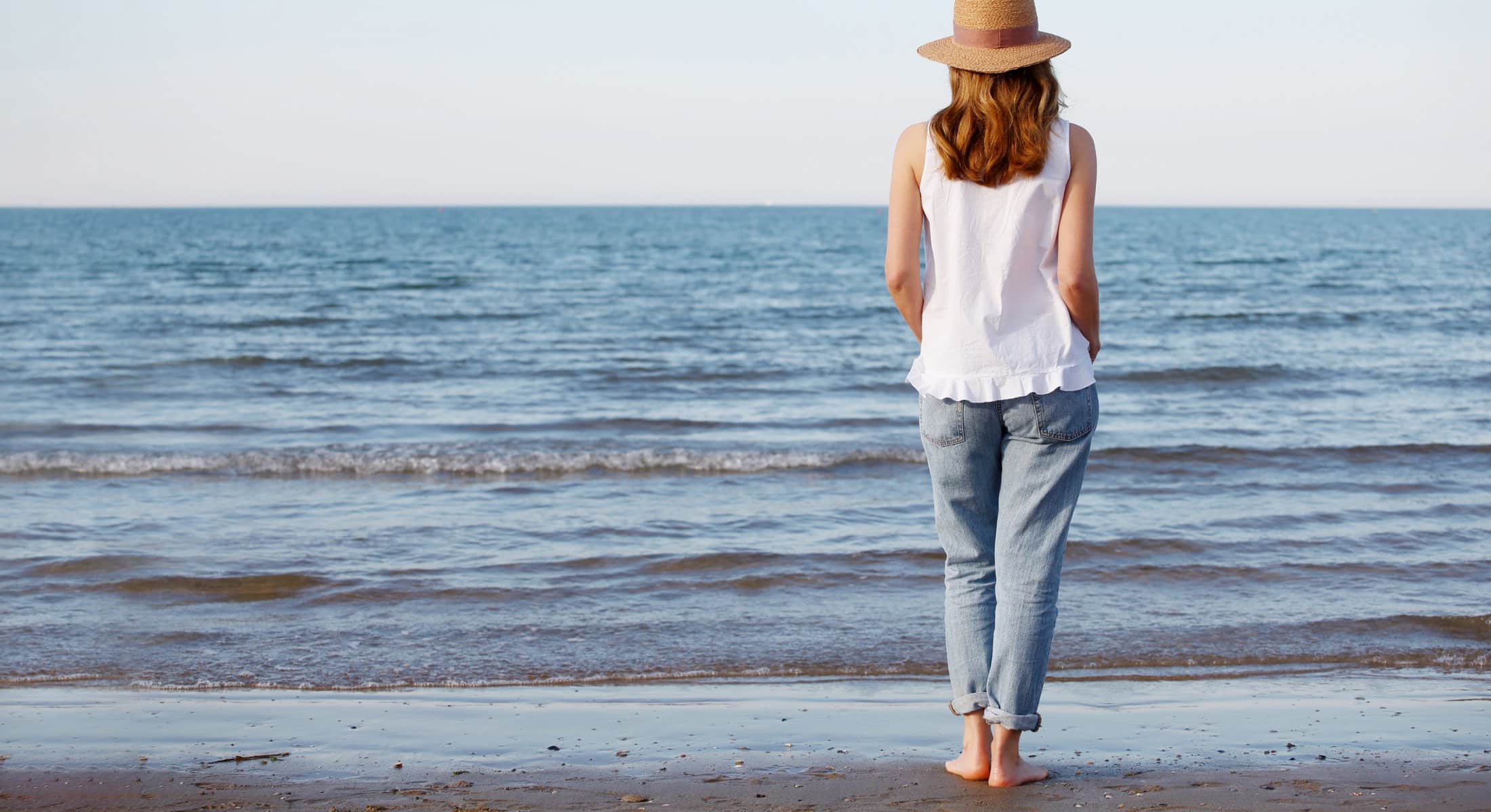 Woman looking out over the ocean feature