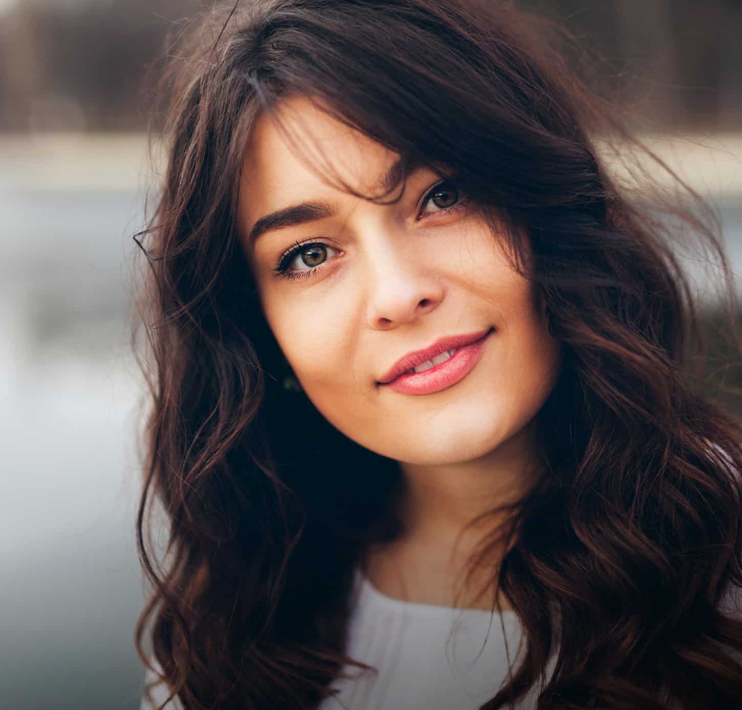 Smiling dark haired woman with head tilted sideways