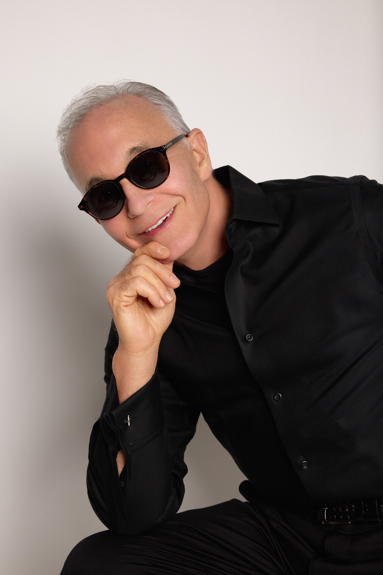 Dr. Michael E. Hill Sitting with sunglasses and black clothes with white background