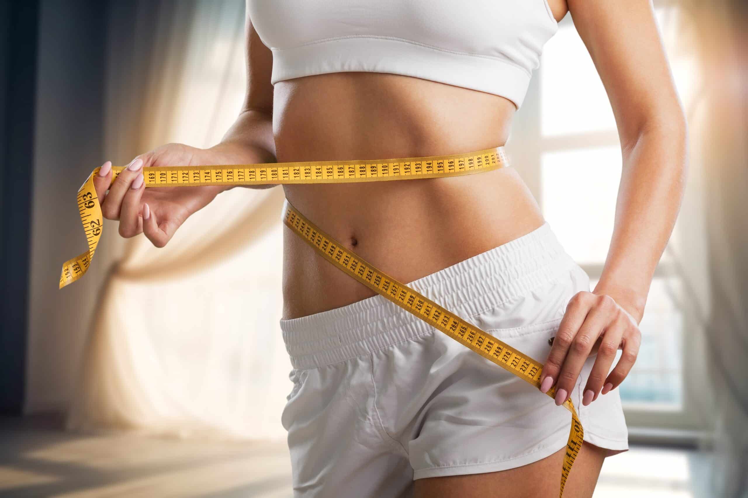 fit woman with healthy weight measuring waist after weight loss with GLP-1